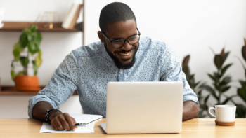 man smiling at laptopscreen